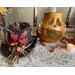 This is a Halloween pumpkin gourd with its grungy top hat sitting next to it. The hat is decorated with a rope and dried botanical berries.